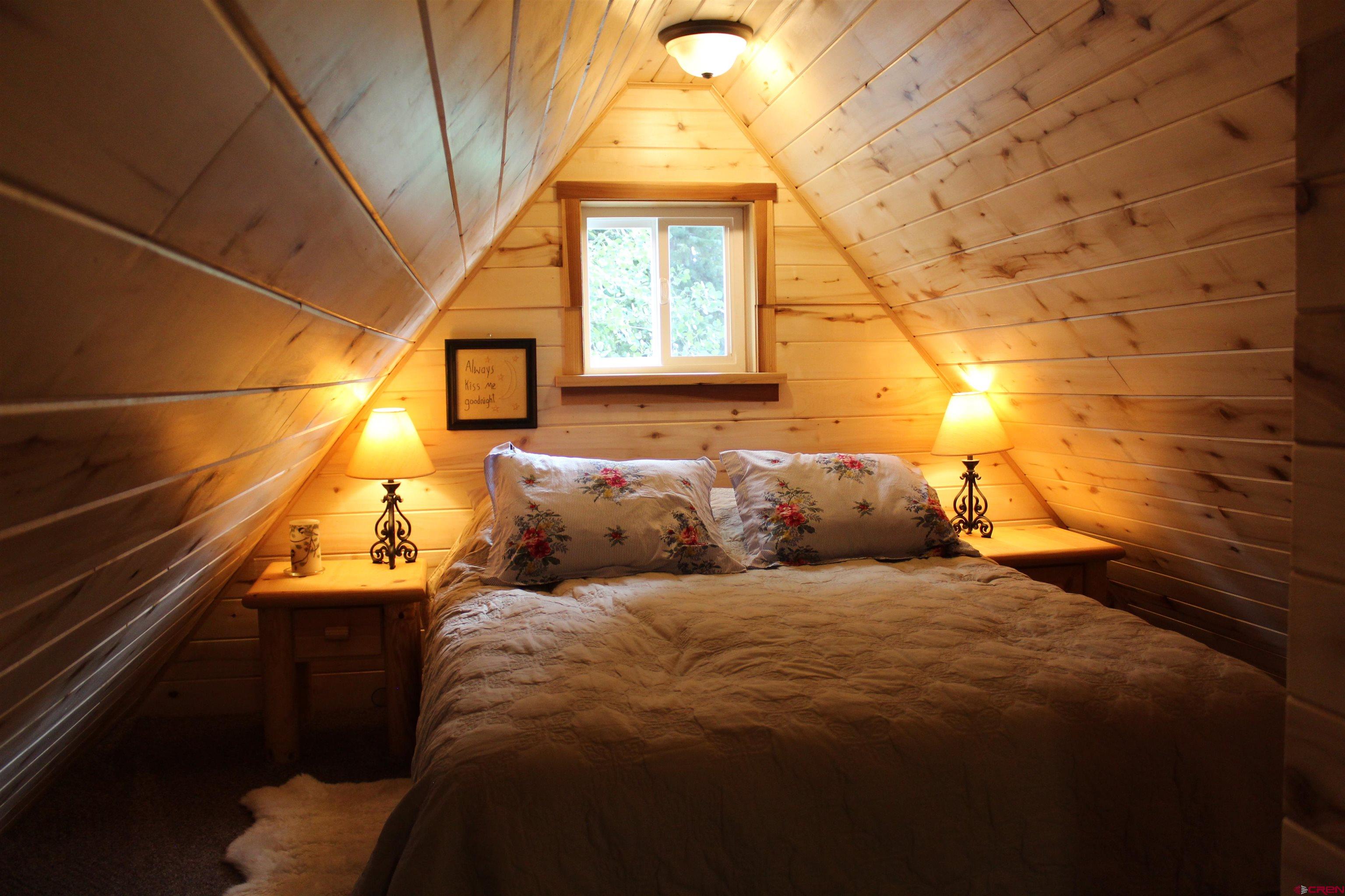 21629 Baron Lake Drive Cedaredge, CO 81413 - Photo 16 of 34 a bed sitting in a bedroom next to a window