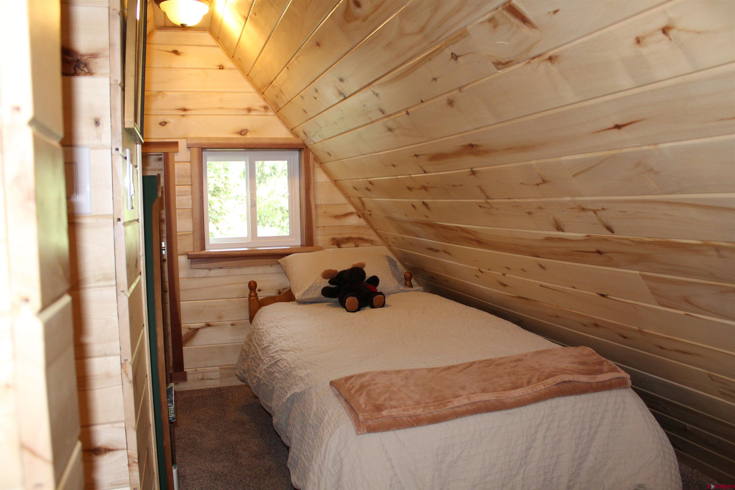 21629 Baron Lake Drive Cedaredge, CO 81413 - Photo 18 of 34 a bedroom with a bed and a window