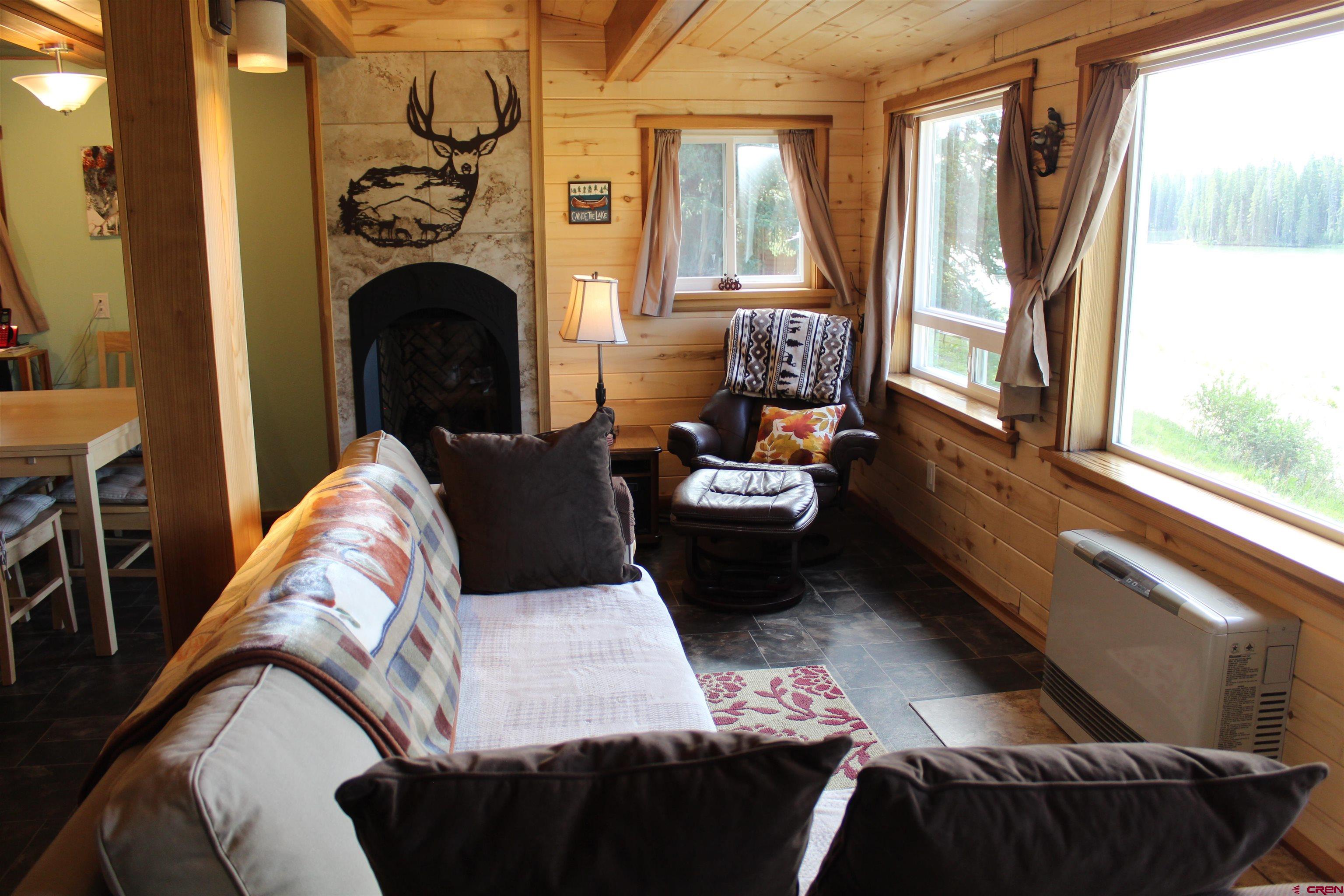 21629 Baron Lake Drive Cedaredge, CO 81413 - Photo 29 of 34 a living room with furniture and a fireplace