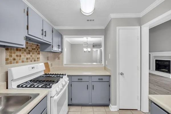 a kitchen with white cabinets and appliances