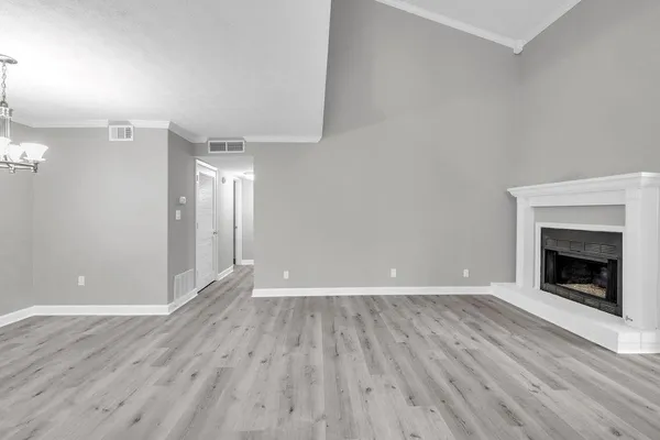 an empty room with wooden floor and fireplace