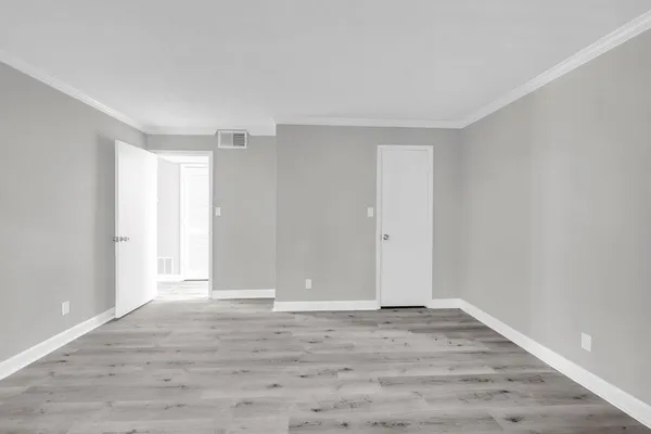 a view of an empty room with wooden floor
