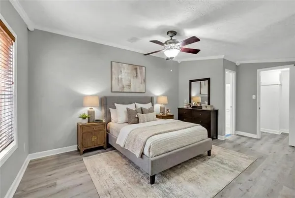 a bedroom with a bed chandelier and a window