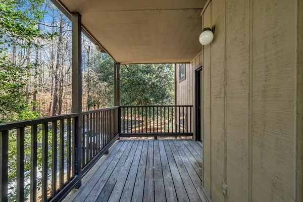a view of a balcony with wooden floor and fence