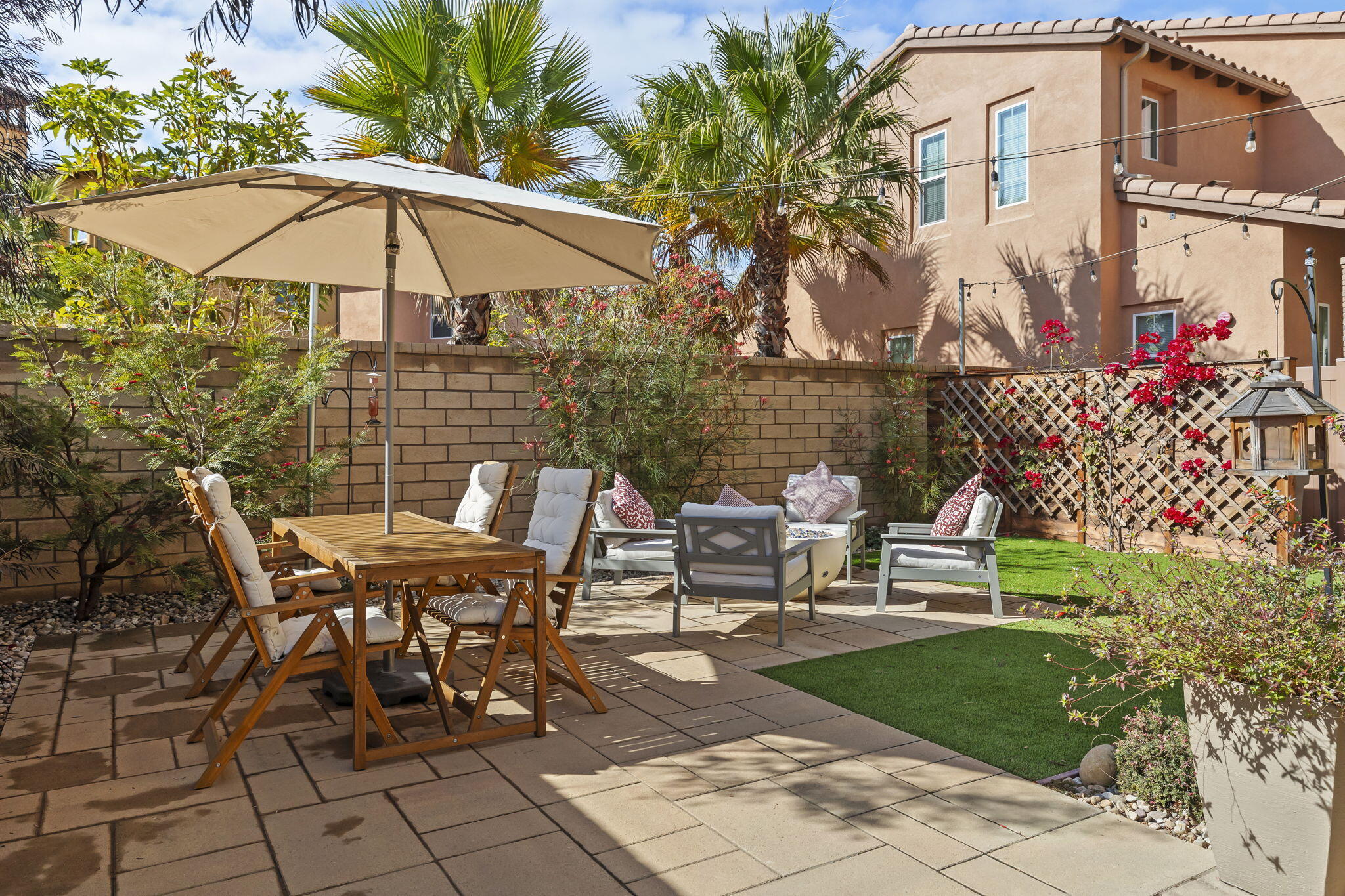 a view of a patio with a table and chairs under an umbrella