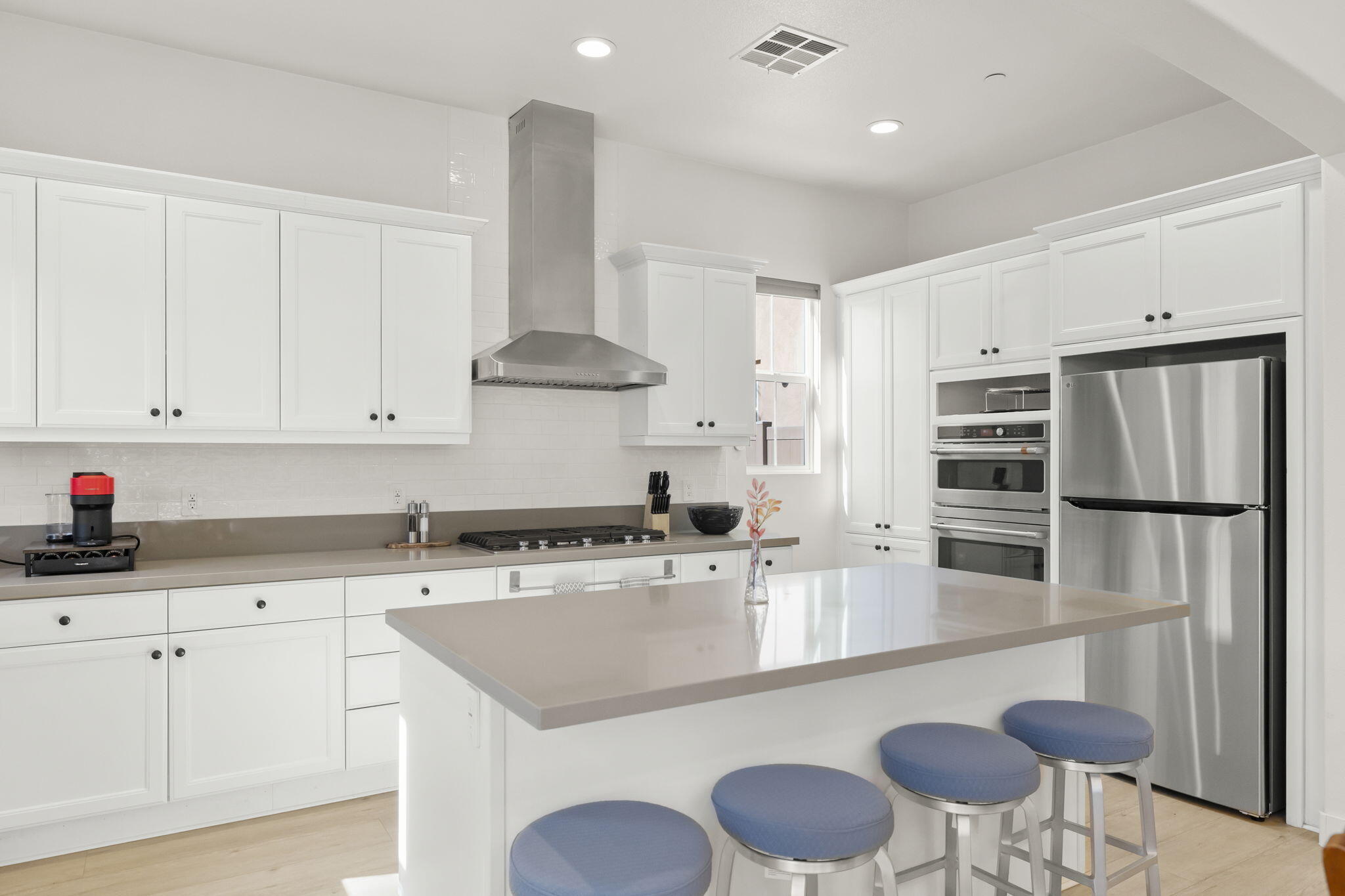 2339 Nicklaus Street Oxnard, CA 93036 - Photo 13 of 50 a kitchen with stainless steel appliances granite countertop a sink a stove a refrigerator and white cabinets with wooden floor