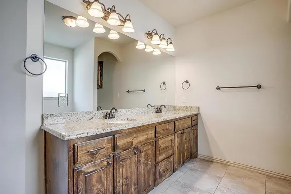 a bathroom with a sink a light fixture and a mirror