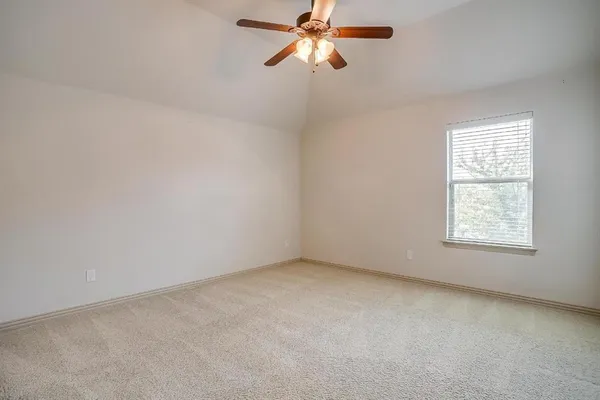 an empty room with a window and a fan