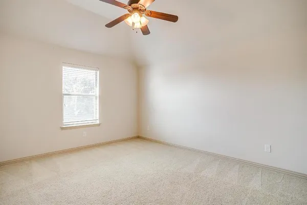 an empty room with a window and a fan