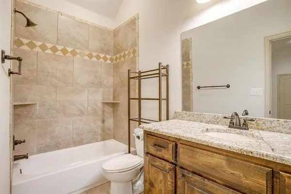 a bathroom with a granite countertop sink toilet and shower