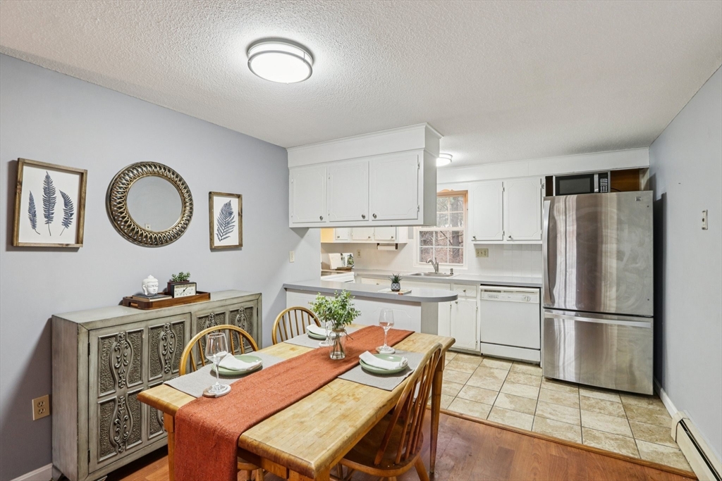 3 Drummer Road, Unit B3 Acton, MA 01720 - Photo 3 of 16 a kitchen with a dining table chairs and a refrigerator