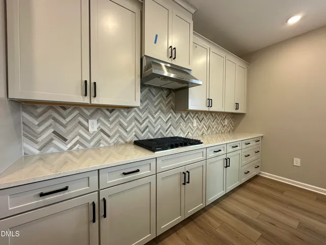 a kitchen with stainless steel appliances granite countertop a sink a stove and cabinets