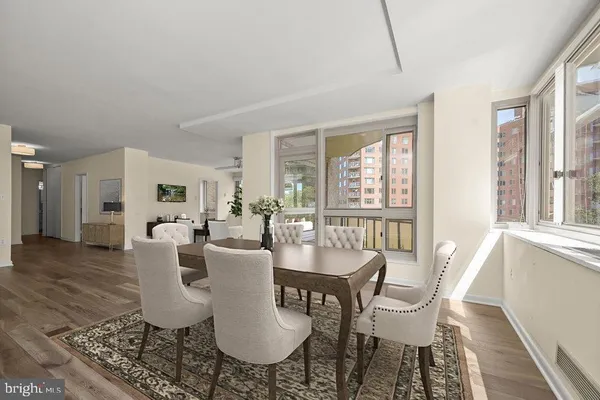a dining room with furniture a chandelier and wooden floor