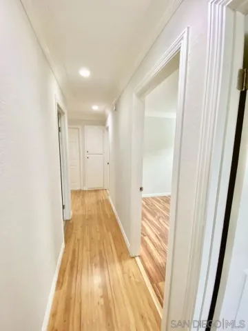 a view of a hallway with wooden floor