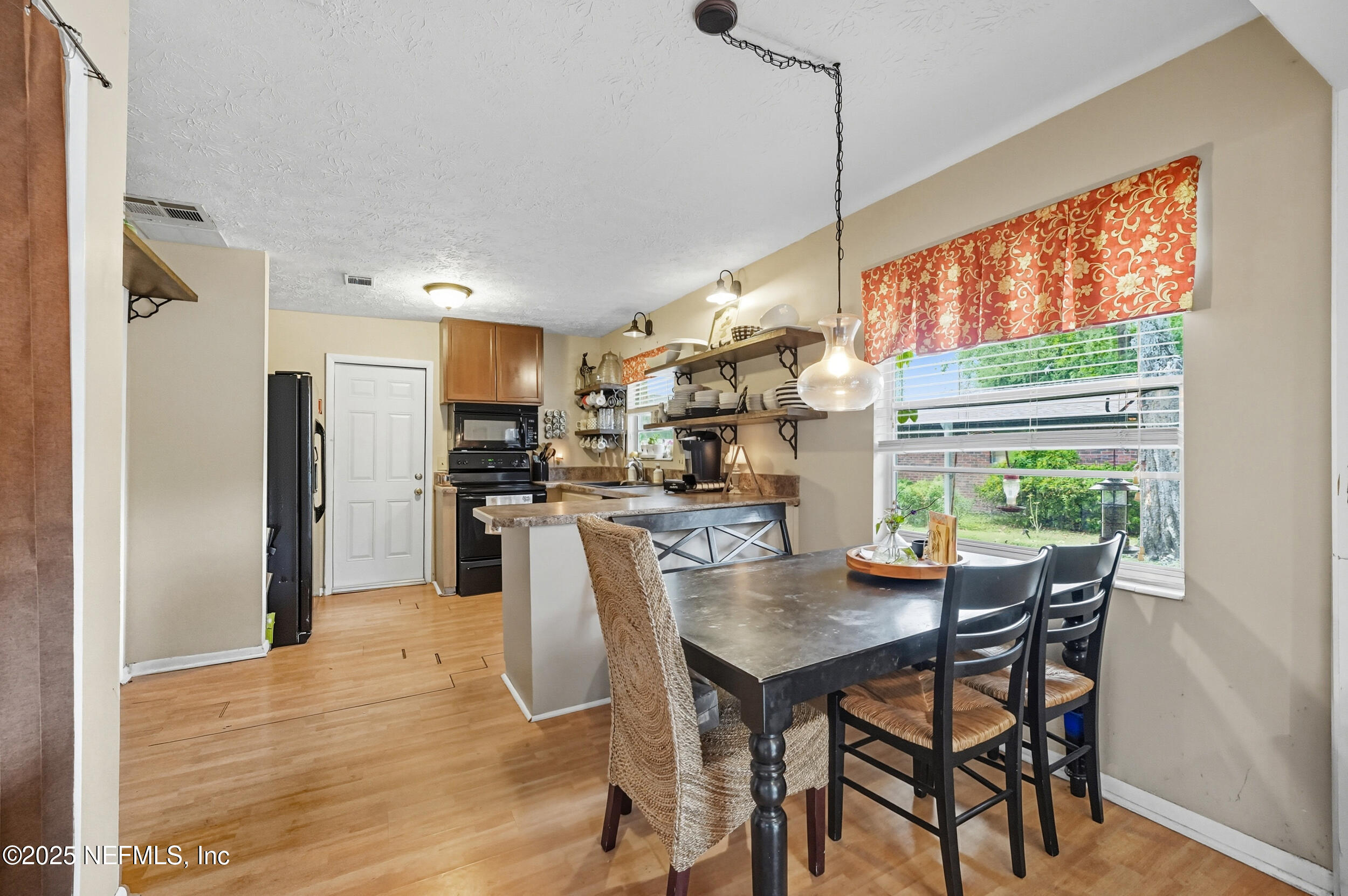 5396 Golf Course Drive Jacksonville, FL 32277 - Photo 4 of 62 a kitchen with stainless steel appliances granite countertop a kitchen island a stove a table and a refrigerator