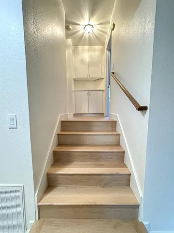 a view of staircase with white walls and railing