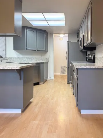 a kitchen with stainless steel appliances granite countertop a sink a stove and a refrigerator