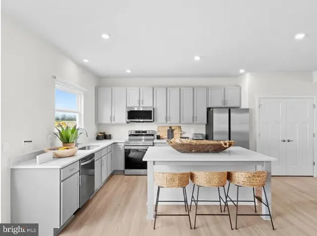 a kitchen with a stove a sink a dining table and chairs