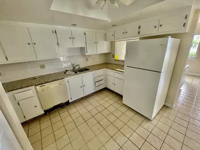 a kitchen with white cabinets and white appliances