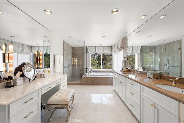 a large white kitchen with a large window and stainless steel appliances