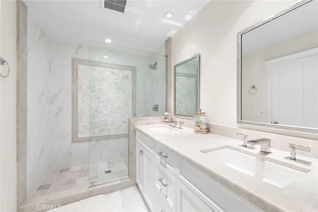 a bathroom with double vanity sinks and a mirror