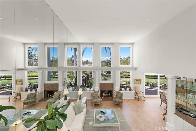 a living room with furniture large windows and wooden floor