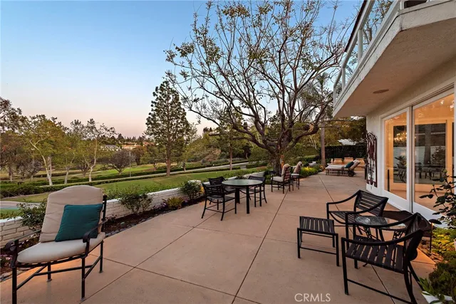 a view of a patio with couches table and chairs and potted plants