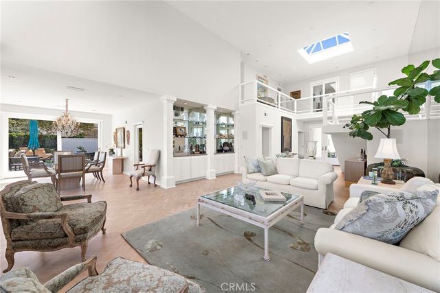a living room with furniture potted plant and a large window