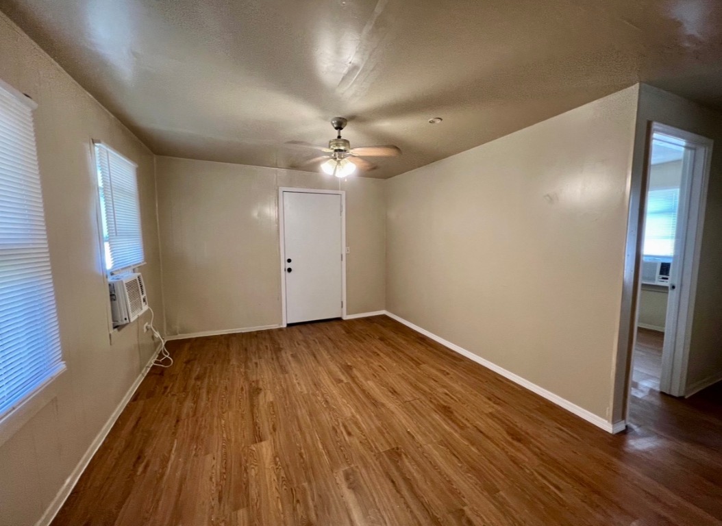 514 Ruddy Street, Unit A Lockhart, TX 78644 - Photo 8 of 9 an empty room with wooden floor and a ceiling fan