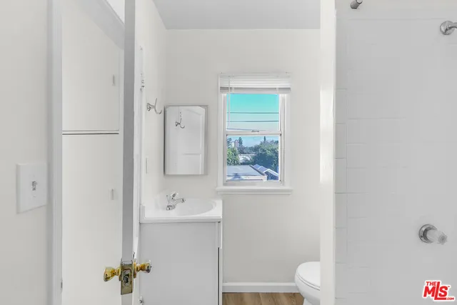 a bathroom with a toilet a sink and mirror