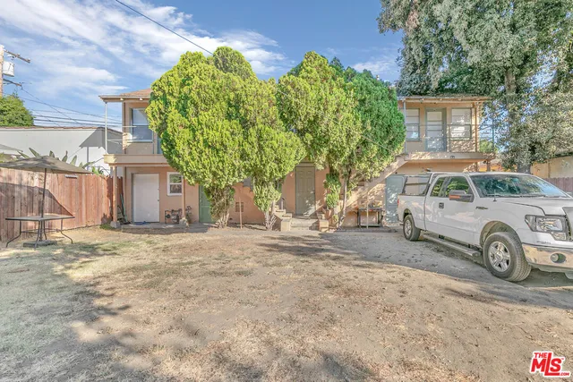 a view of a patio with a table and chairs under an umbrella