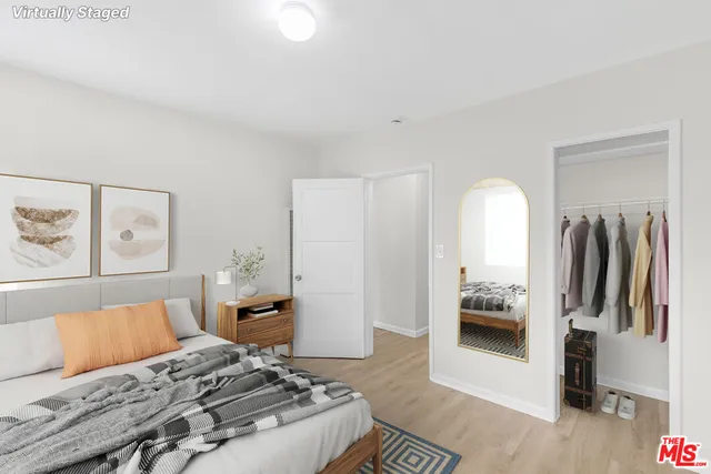 a bedroom with a bed and a view of living room