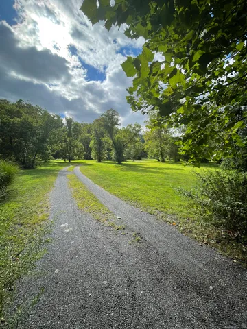 a view of a green field with wooden fence