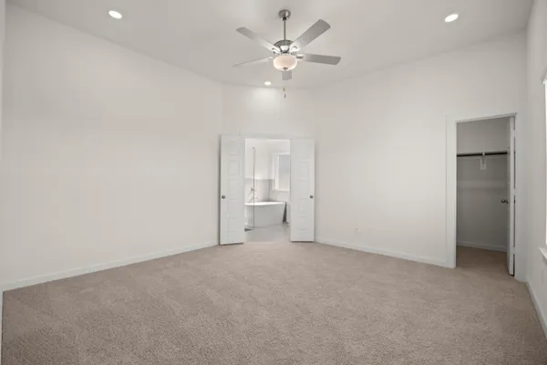 an empty room with a ceiling fan and a window
