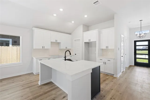 a kitchen with a sink appliances and cabinets