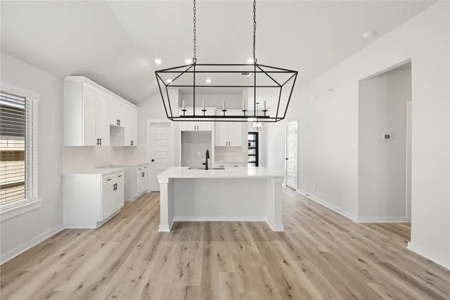 a view of kitchen with stainless steel appliances granite countertop a sink and wooden floor