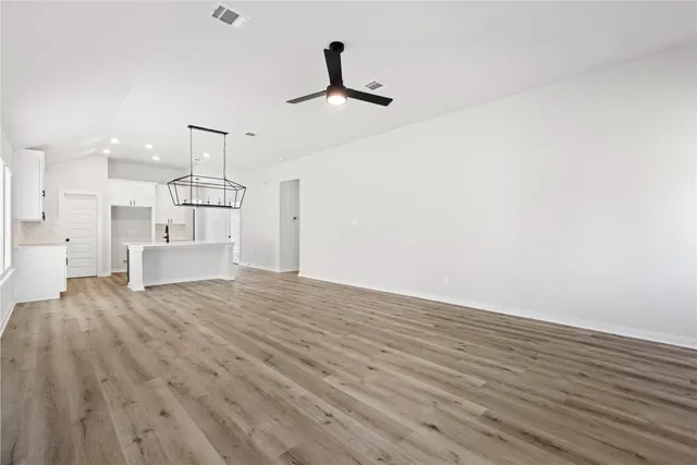 a view of empty room with wooden floor