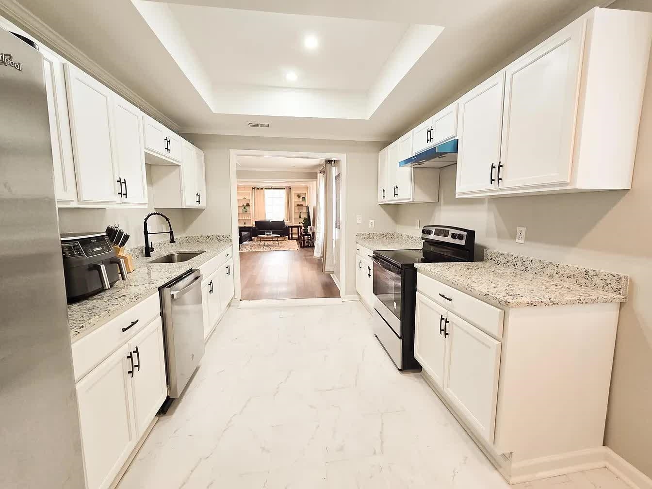 15 South Cox Street Memphis, TN 38104 - Photo 3 of 20 a kitchen with granite countertop a sink a stove top oven a refrigerator a counter top space and cabinets