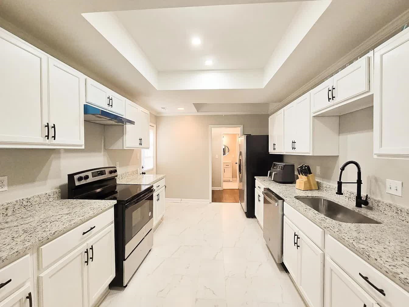 15 South Cox Street Memphis, TN 38104 - Photo 8 of 20 a kitchen with stainless steel appliances granite countertop a sink stove and refrigerator
