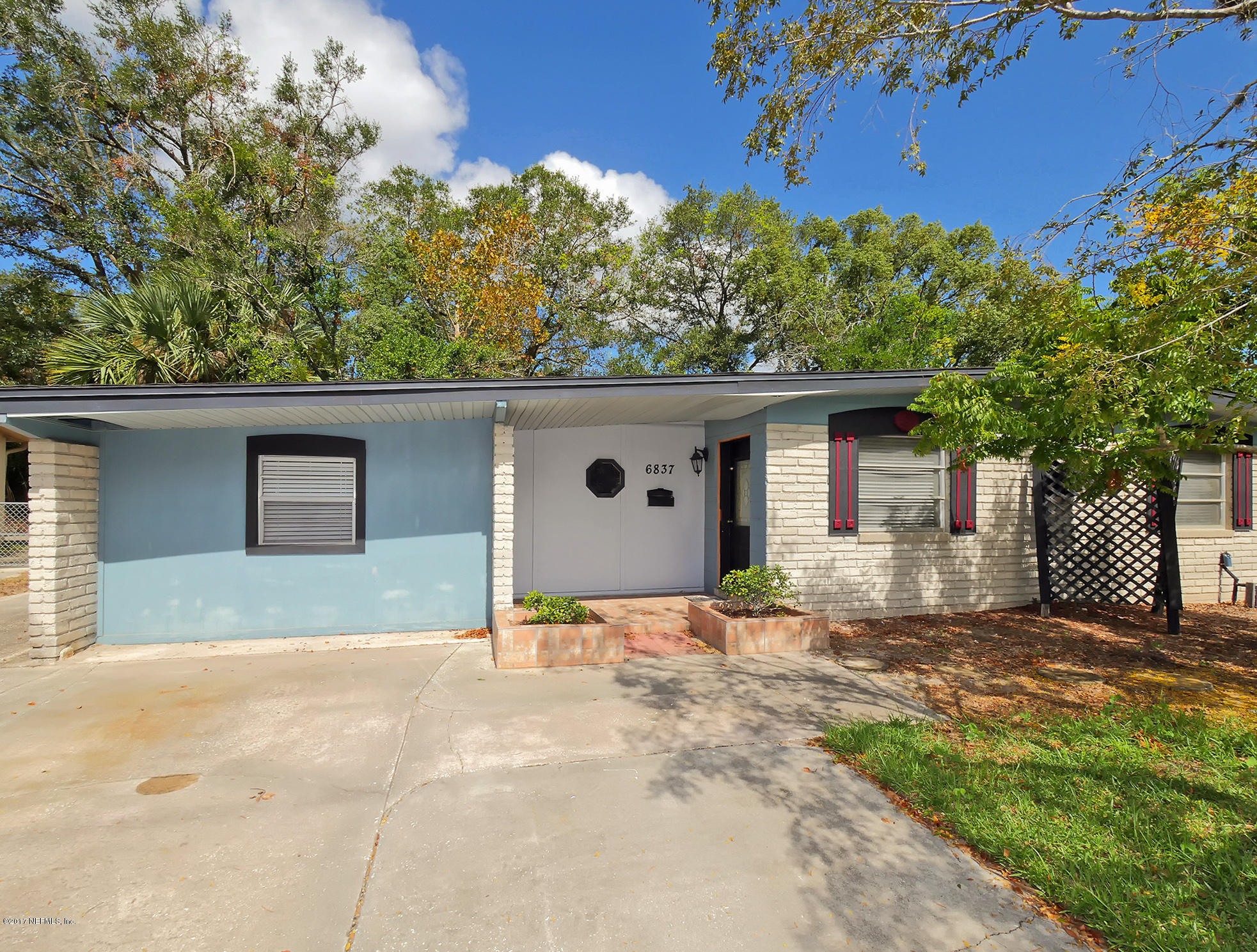 6837 Merrill Road Jacksonville, FL 32277 - Photo 3 of 13 a front view of a house with a yard and garage
