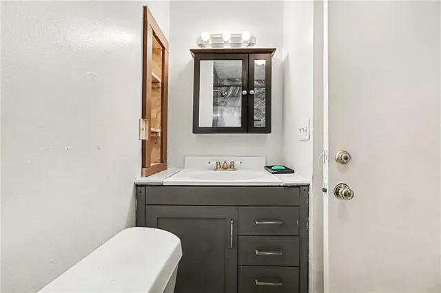 a bathroom with a toilet a sink and mirror