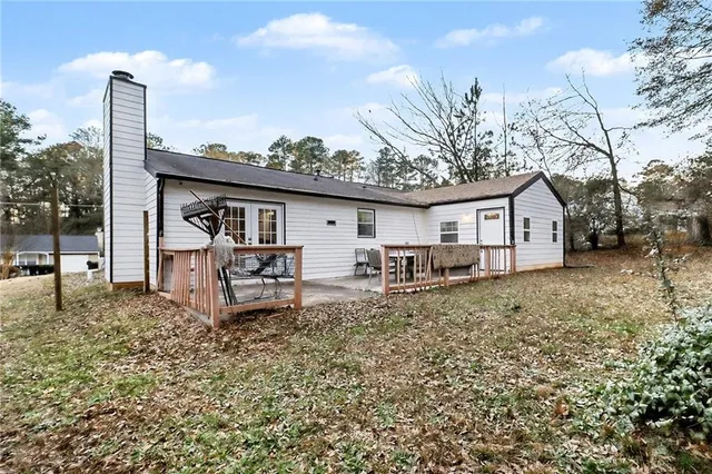 a view of a house with backyard and a tree
