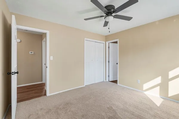 an empty room with windows and ceiling fan