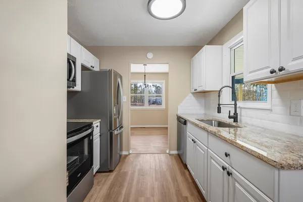 a kitchen with a sink refrigerator and cabinets