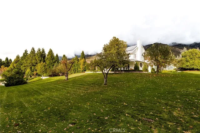 a view of a fountain in front of a house with a big yard