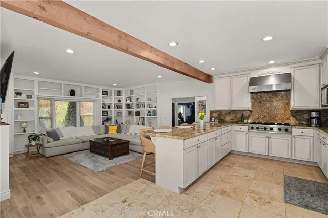 a kitchen with granite countertop a sink and white cabinets