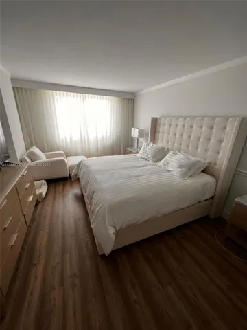 a view of a hallway with wooden floor and furniture