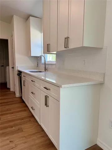 a kitchen with stainless steel appliances granite countertop a sink and a stove with wooden floor