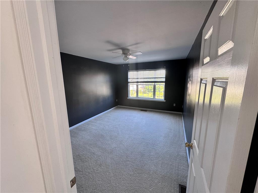 5494 Spring Ridge Drive West Macungie, PA 18062 - Photo 16 of 20 Plush carpeting anchors this spacious bedroom featuring a wide window overlooking the yard.