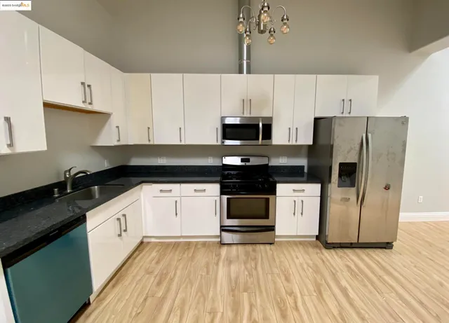 a view of a kitchen with a stove wooden floor and a kitchen